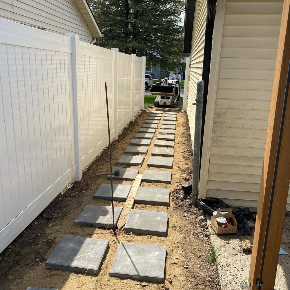 Paver walkway installation running along the property line